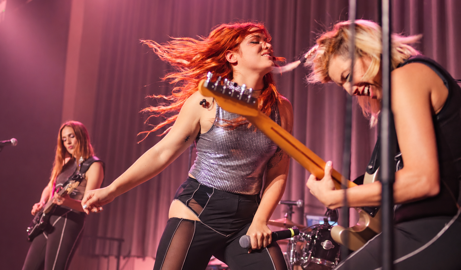 Adelyne en directo bajo luces rosa y malva